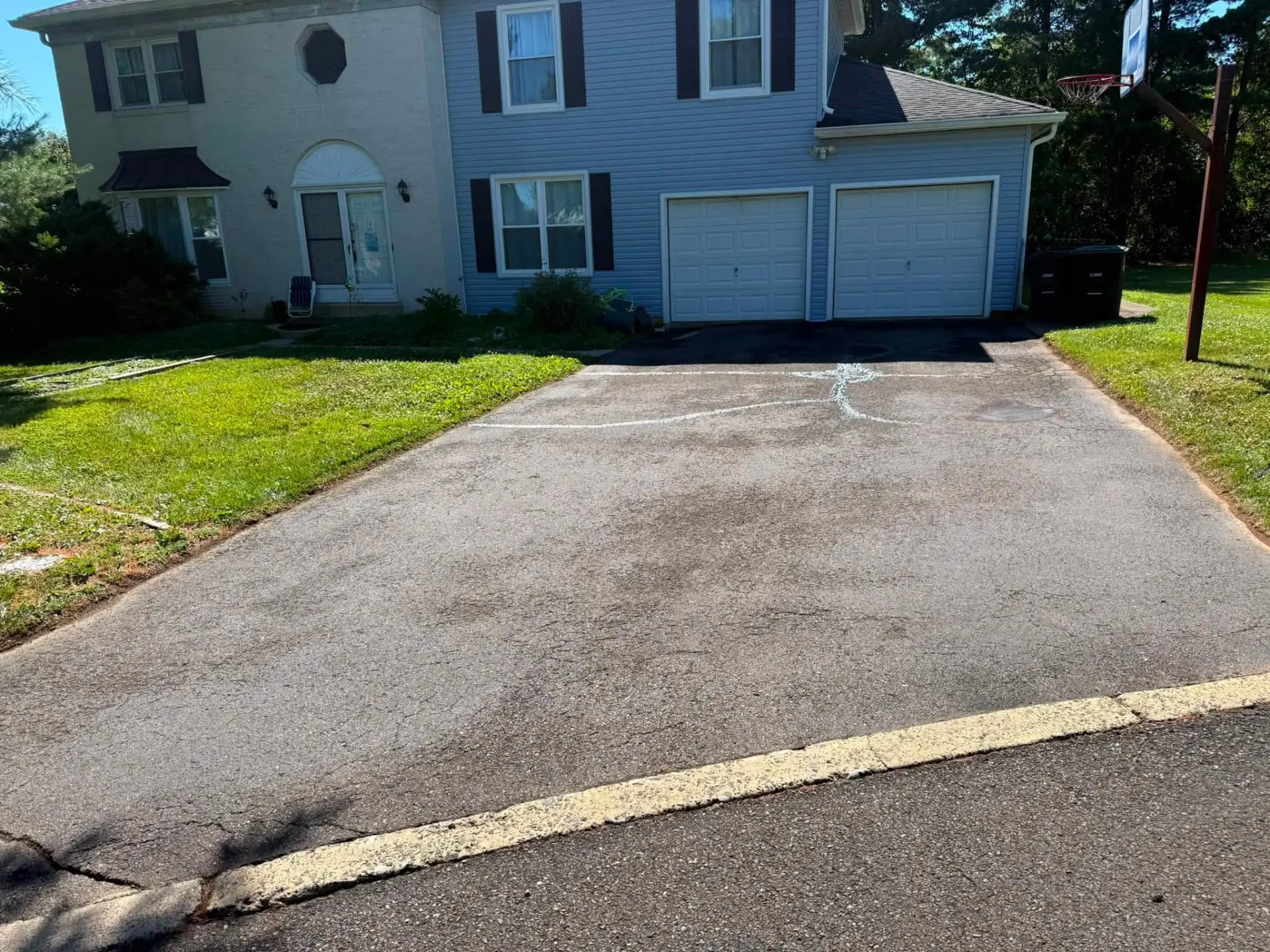 Cracked and faded asphalt driveway in Philadelphia, PA before sealcoating